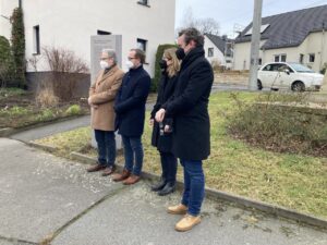 Teilnehmende der Einweihung stehen vor dem Obelisk