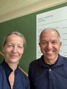 2 Personen vor dem Schild des Notariats Korte, links Juliane, rechts Matthias
