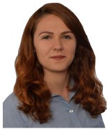 Junge Frau mit langen rotbraunen Haaren und grauer Bluse