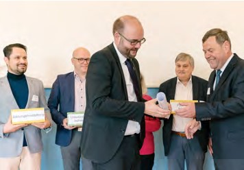 Thomas Emmrich übergibt eine Papierrolle an Staatsminister Piwarz