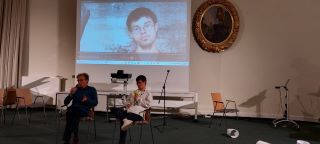 Im Vordergrund Pascal Kries, auf der Leinwand hinter ihm läuft sein Film.