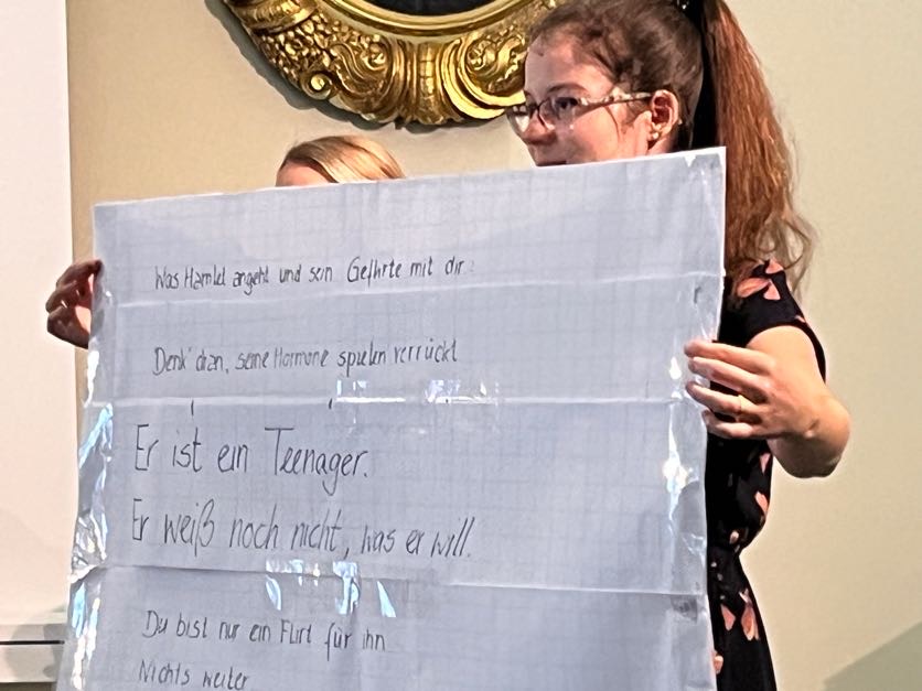 2 Personen halten ein Plakat mit leicht verständlichem Text