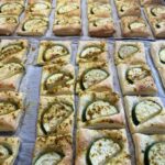 Gebackene Blätterteigquadrate mit Zucchinischeiben darauf